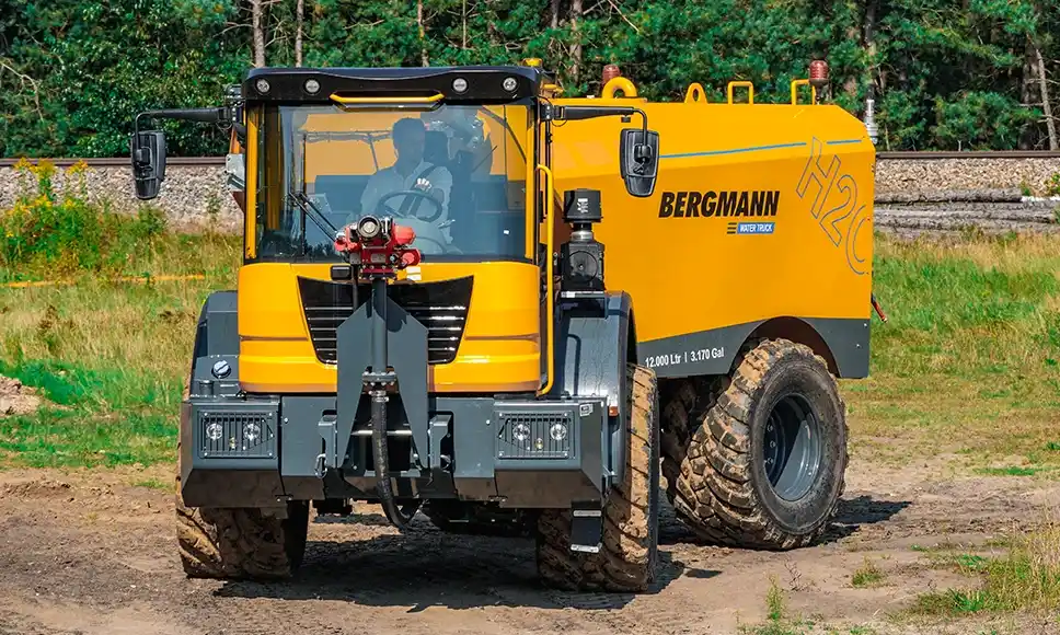 Conductor del camión Bergmann realizando una maniobra de giro en un entorno forestal, destacando su alta maniobrabilidad gracias al chasis articulado, menor radio de giro y sistema de tracción 4x4.